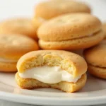 Golden Madeline cookies filled with creamy goodness, arranged elegantly on a white plate.