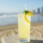 A refreshing Lemon San Diego Cocktail served in a chilled glass, garnished with a lemon twist, set against a wooden bar counter.